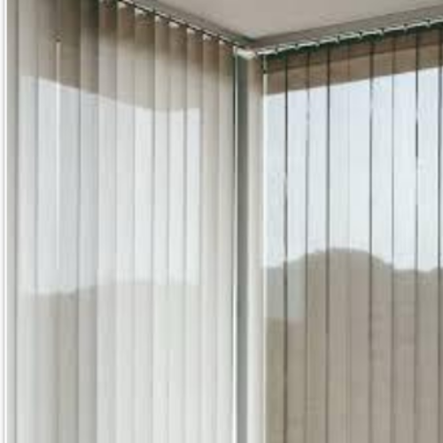 Persianas verticales de tela en una sala con ventanas grandes.